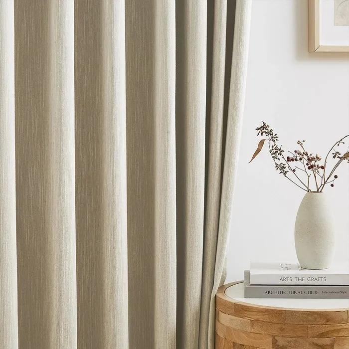 beige striped curtain folds beside a table