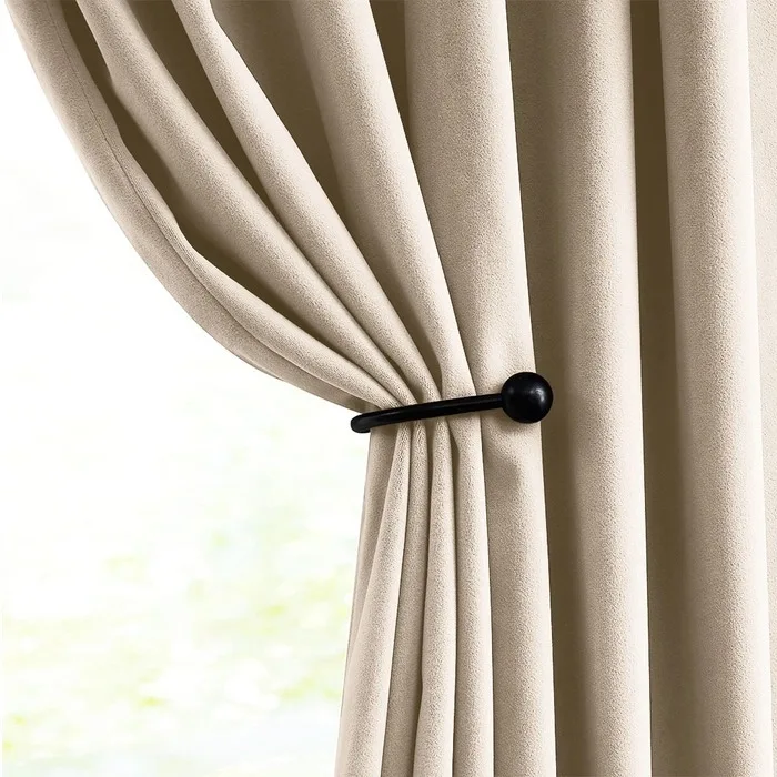 beige velvet curtain tied back at a window