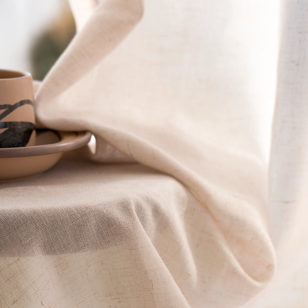 Natural linen-blend curtain fabric showing slubby texture in beige and sand tones