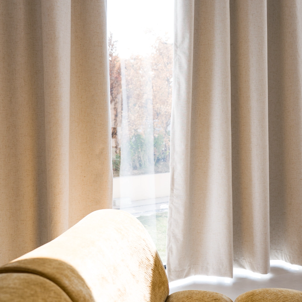 Warm neutral curtains in cream and oat tones draped near a window