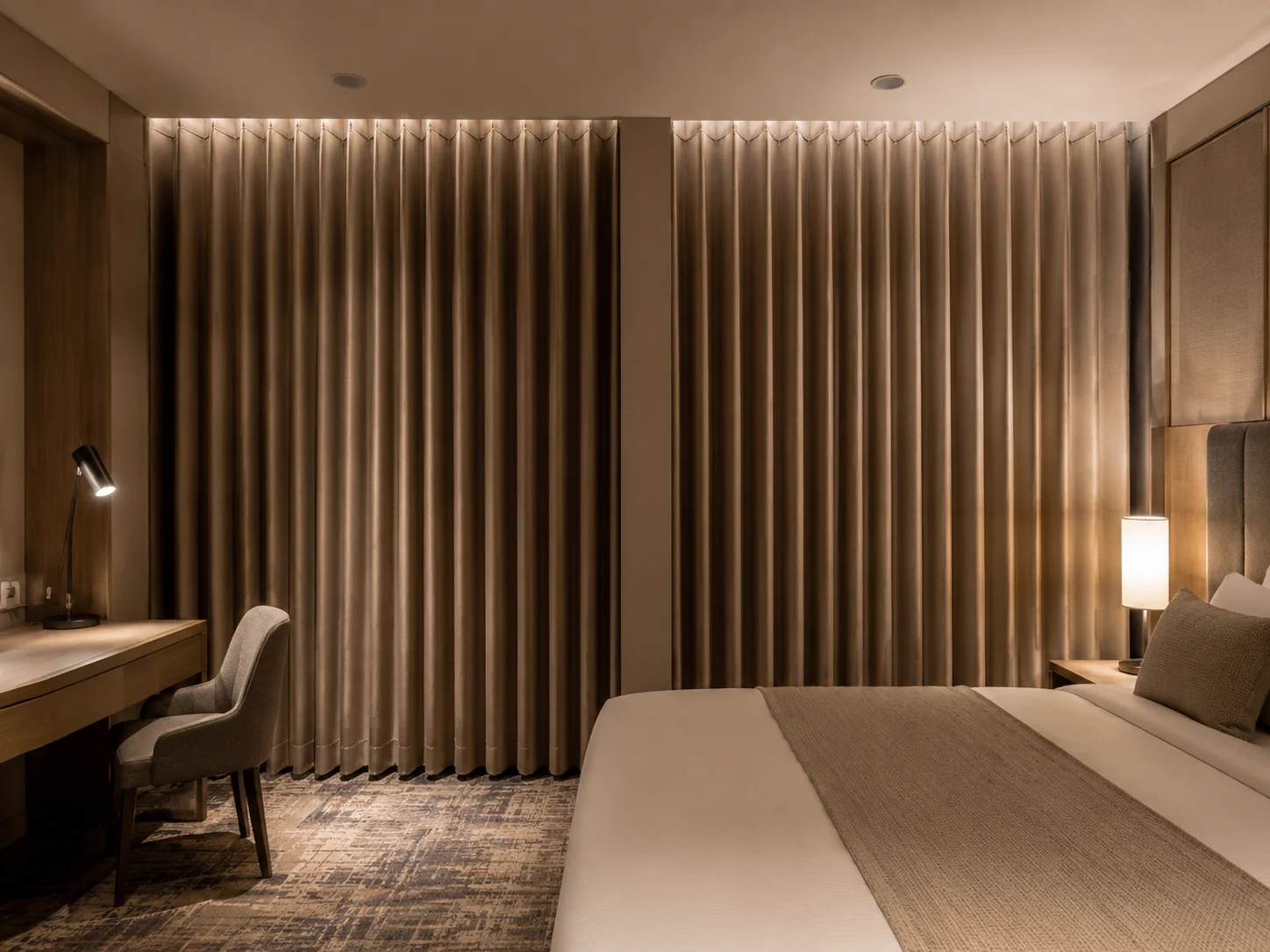 Hotel guest room blackout curtains in beige with consistent Ripplefold heading folds