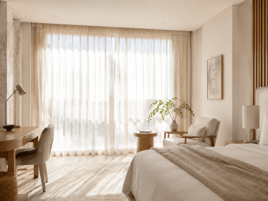Hotel sheer voile curtains in cream filtering bright morning daylight