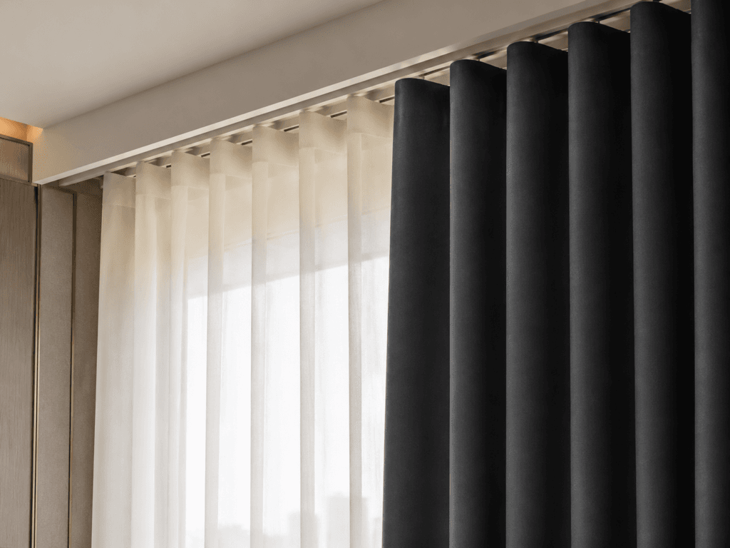 Double-layer hotel curtain system showing sheer behind blackout with ceiling track