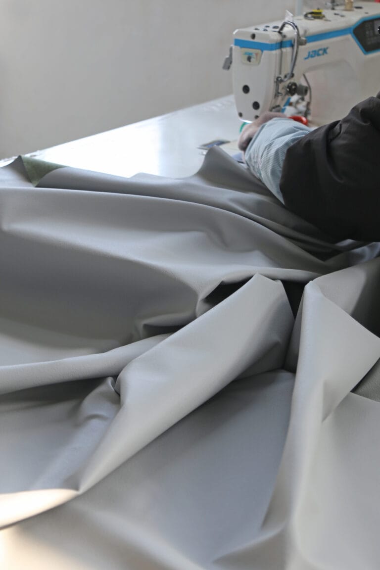Coated blackout curtain fabric on the sewing table showing face and coated back
