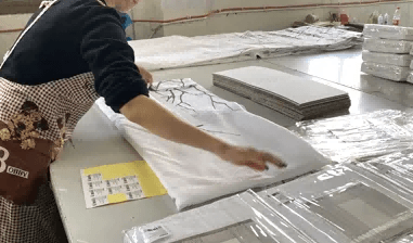Worker inspecting and packing finished curtains at a pre-shipment quality check