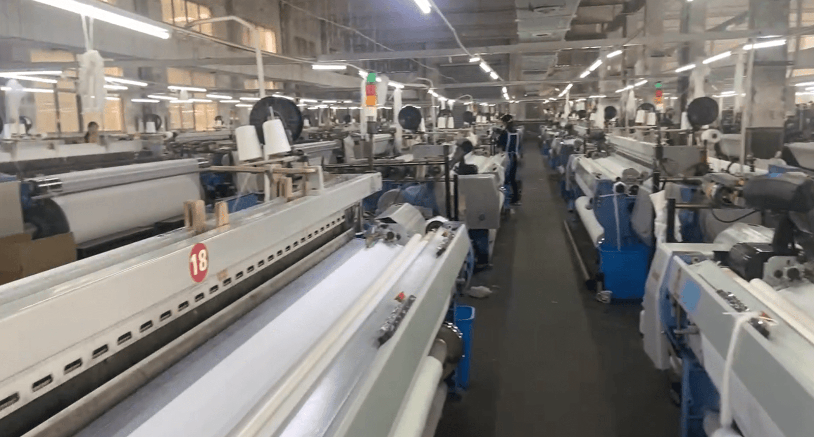 Curtain fabric weaving mill with rows of looms at a China textile manufacturer