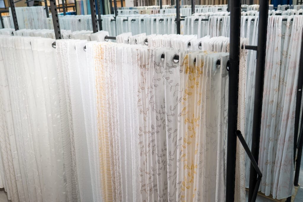 Close-up of embroidered sheer curtain panels with grommet headers