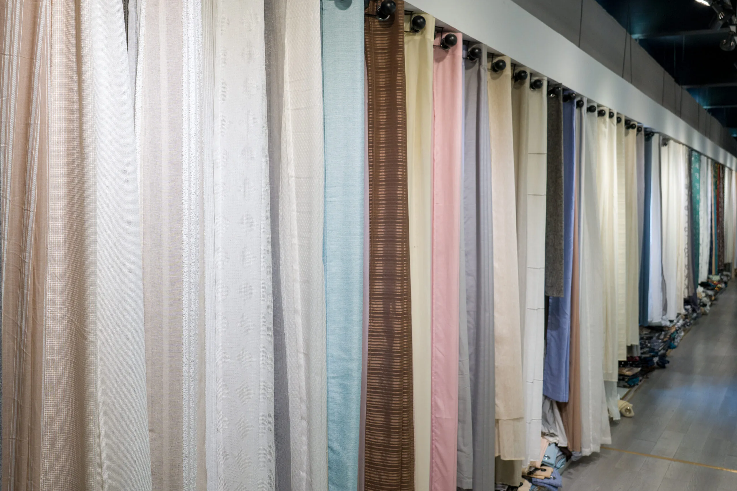 Mid-weight linen-look curtain fabrics displayed in a wholesale showroom