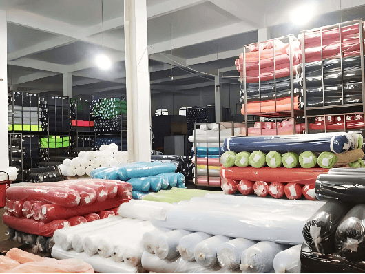 Warehouse stocked with rolls of curtain fabric in assorted colors for wholesale