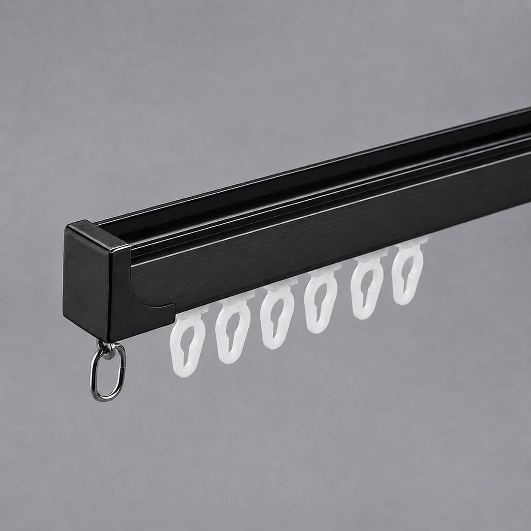 Black aluminium curtain track with white nylon gliders