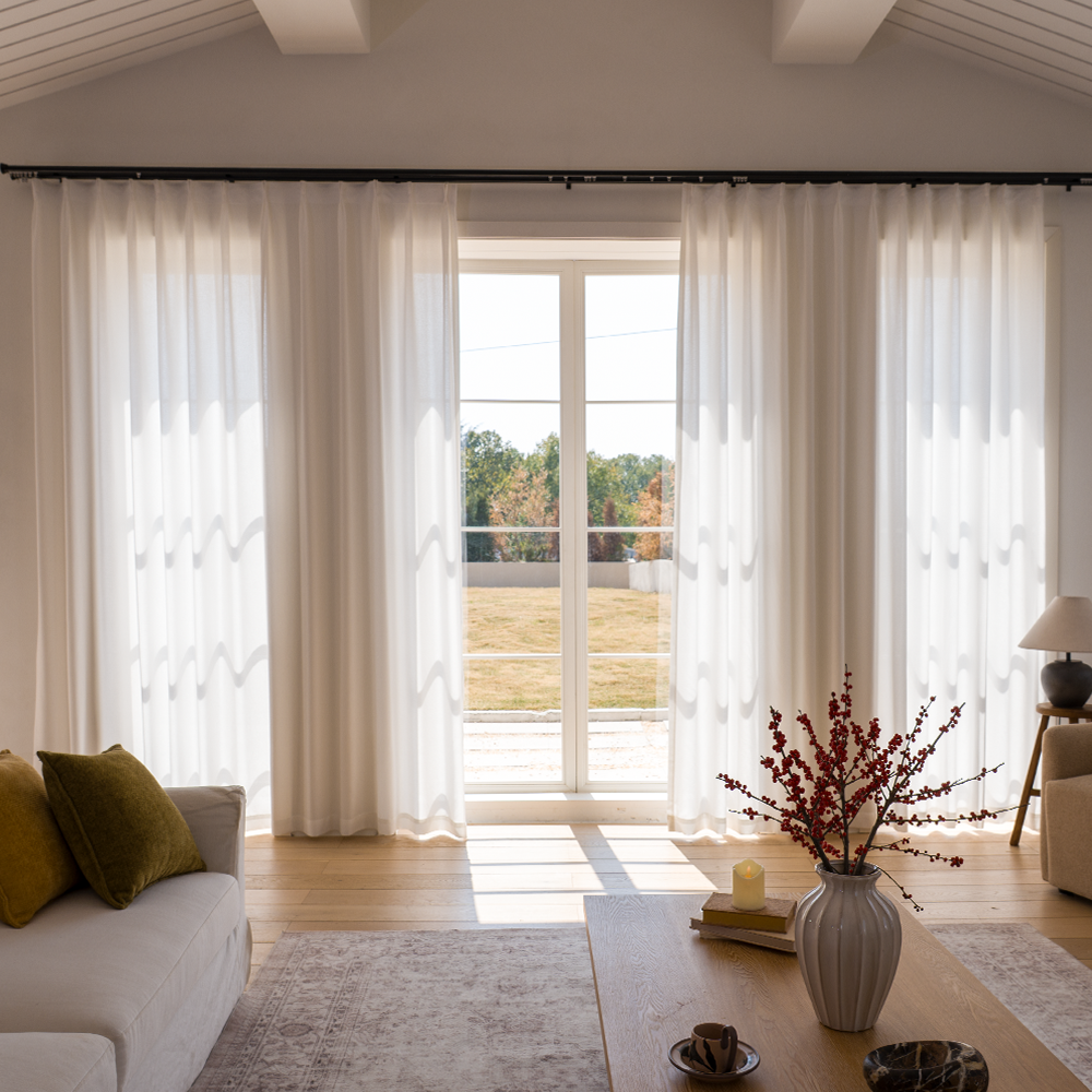 Full-height sheer curtain panels viewed in daylight with visible folds