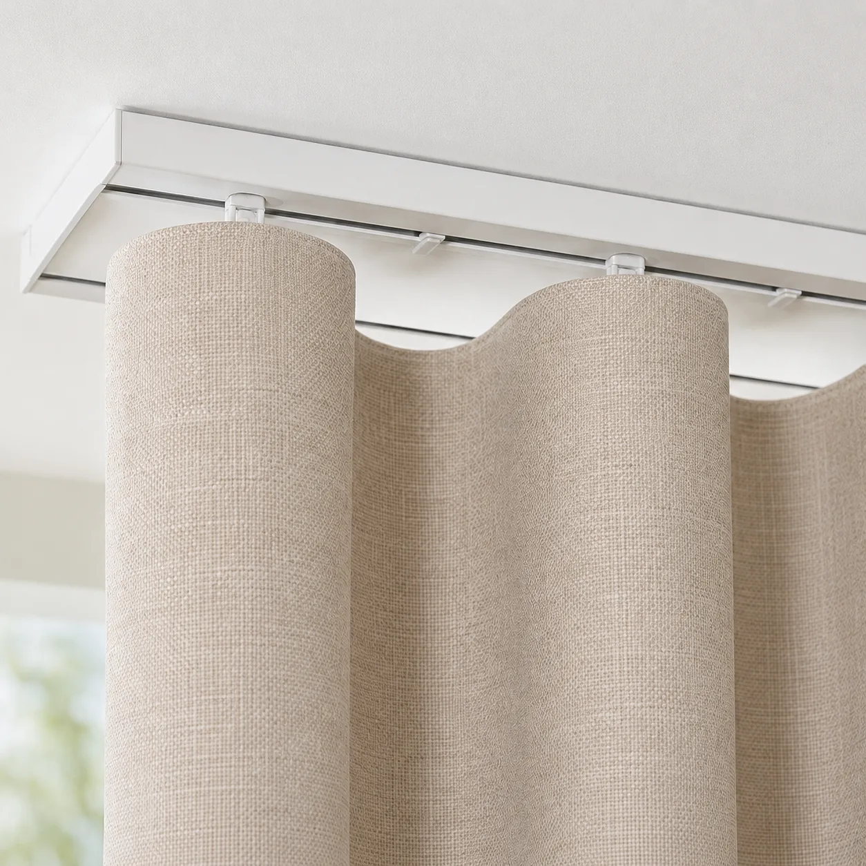 Wave curtain heading and gliders on a ceiling-mounted track, rail concealed behind the panel